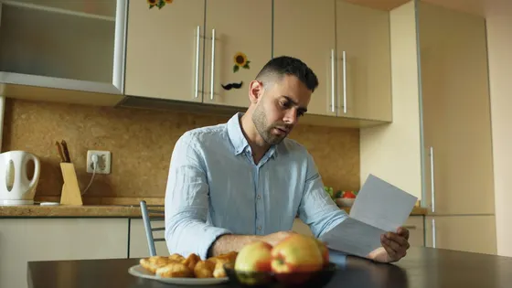Person reviewing household bills at a table